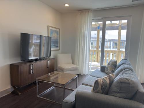 a living room with a couch and a flat screen tv at The Pointe Unit 342 by 30A Escapes in Rosemary Beach