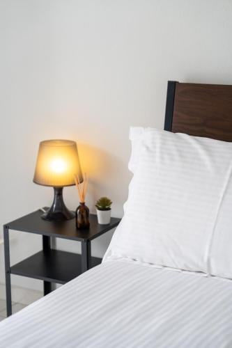 a bed with a table with a lamp on it at Thalori Akra escape in Paralía Akrátas