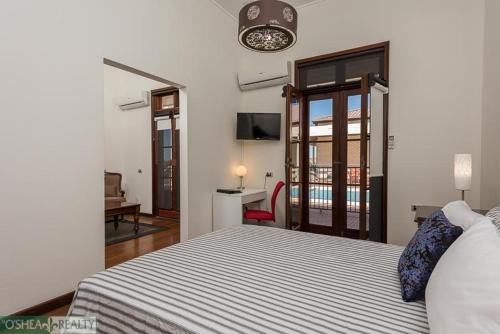 a bedroom with a bed and a room with a balcony at Fairway Manor Accomodation in Northam