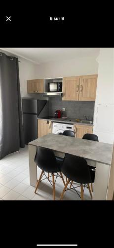 une cuisine avec une table et des chaises dans l'établissement Appartement saisonnier, à Mandelieu-la-Napoule