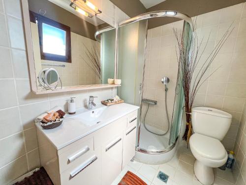 a bathroom with a shower and a toilet and a sink at Boho Mare Retreat - Skala Fourkas in Skála Foúrkas
