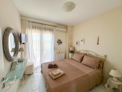 a bedroom with a bed with a mirror and a window at Boho Mare Retreat - Skala Fourkas in Skála Foúrkas