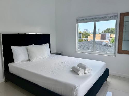 a bedroom with a bed with two towels on it at Renzzi Villas in Miami