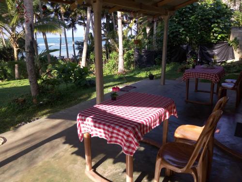 a table with a red and white checkered table cloth at SunRay Rest - Beach View Homestay in Mirissa