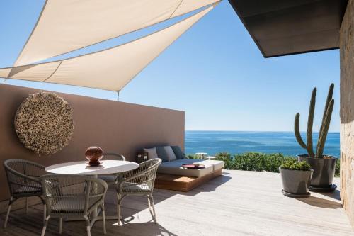 a patio with a table and chairs and a couch at Zadún, a Ritz-Carlton Reserve, Los Cabos in San José del Cabo