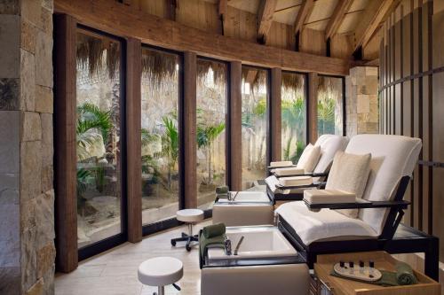 a salon with white chairs and tables and windows at Zadún, a Ritz-Carlton Reserve, Los Cabos in San José del Cabo
