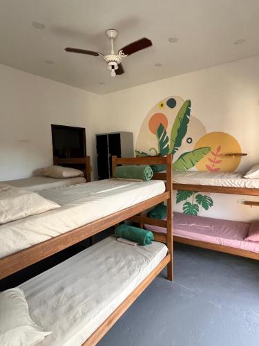 a room with three bunk beds and a ceiling at Marola Hostel in Ubatuba