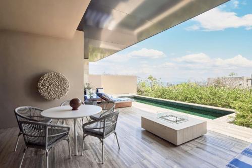 a living room with a table and chairs and a view of the ocean at Zadún, a Ritz-Carlton Reserve, Los Cabos in San José del Cabo