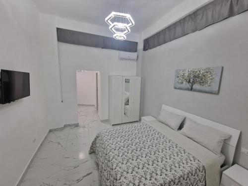 a white bedroom with a bed and a tv at Marilissa Home in Bari