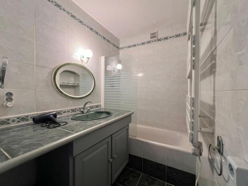 Maison 12 personnes max proche Mer et parkings gratuits في لو غراو دو روا: حمام مع حوض و مرآة و حوض استحمام