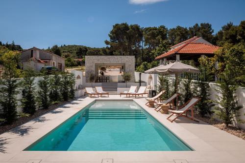 a swimming pool with chairs and a house at Villa Sea Song in Tkon