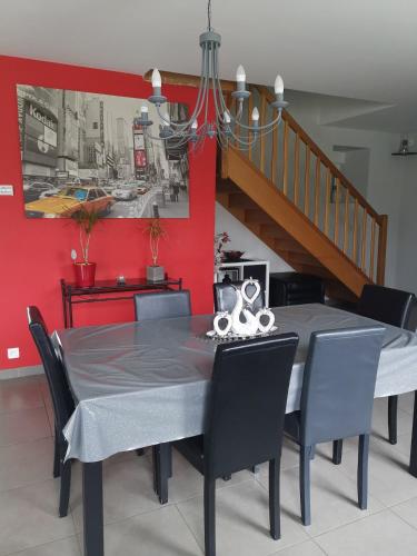 une salle à manger avec une table et des chaises et un escalier dans l'établissement Maison de campagne avec terrain clos, à La Méaugon