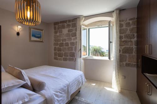 a bedroom with a bed and a large window at Heritage Hotel Park Hvar in Hvar