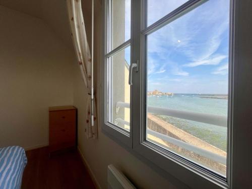 - une fenêtre avec vue sur la plage dans l'établissement Les pieds dans l eau Home - Waterfront Stay, à Barfleur