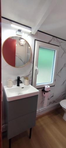 une salle de bain avec un lavabo et un miroir dans l'établissement Charmant Chalet -La Lande - 4 pers-24h du Mans, à Cérans-Foulletourte