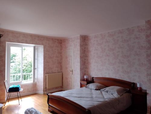 une chambre avec un lit, une fenêtre et une chaise dans l'établissement Charmante maison de centre bourg avec jardin, à Saint-Sozy