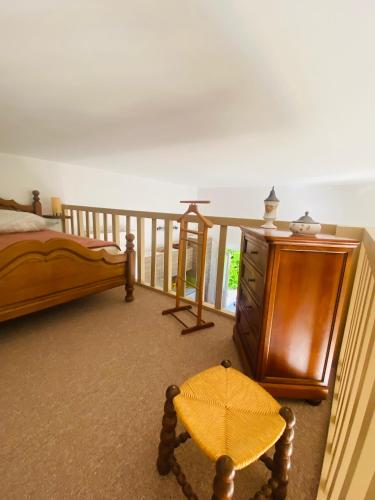 une chambre avec un lit et une commode en bois dans l'établissement Maison, à Fayence
