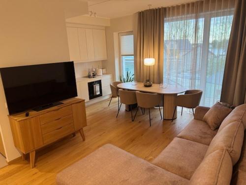 a living room with a couch and a table with a television at Sadama Apartment in Haapsalu
