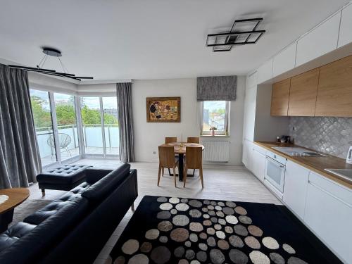 a kitchen and living room with a couch and a table at Apartament Wysockiego in Bielsk Podlaski