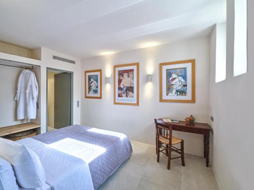 a bedroom with a bed and a desk and a table at Pezoules House in Lefkes