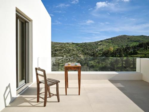 a table and a chair on a balcony with a view at Pezoules House in Lefkes