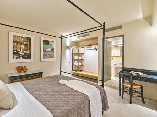 a bedroom with a large bed and a desk at Pezoules House in Lefkes