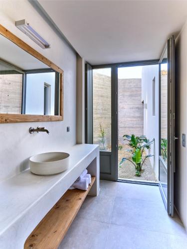 a bathroom with a sink and a large window at Pezoules House in Lefkes