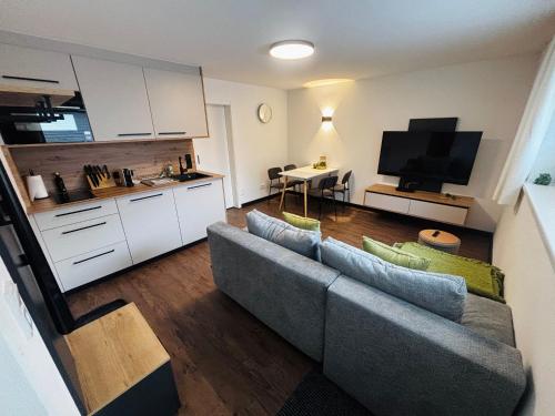 a living room with a couch and a kitchen at KARWENDELBLICK - ein idyllischer Wohlfühlort in Wattenberg