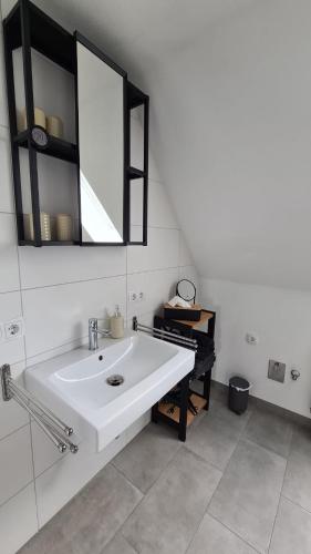 a bathroom with a white sink and a mirror at Ferienwohnung Bettmatten in Ettenheim