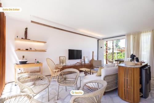 a living room with chairs and a couch and a tv at Casa com Piscina no Origem Fortim in Fortim