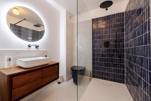 une salle de bain avec un lavabo et une douche en verre dans l'établissement Charmant appartement proche Disney avec Parking, à Montévrain