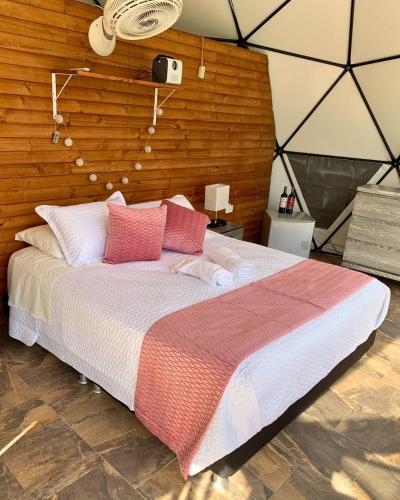 a bedroom with a large bed with a wooden wall at Eco Boutique-Naranjo in La Vega