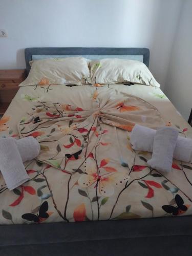 a bed with a comforter with flowers on it at Disha Holiday Home in Ksamil