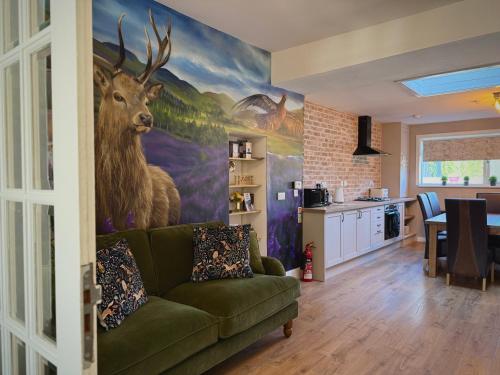 a living room with a painting of a deer on the wall at Wells Street Cottages No 26 By The River Ness in Inverness