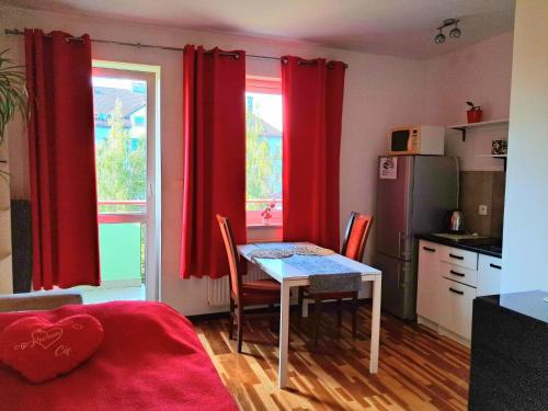 cocina con cortinas rojas y mesa con sillas en Stronska, en Wroclaw