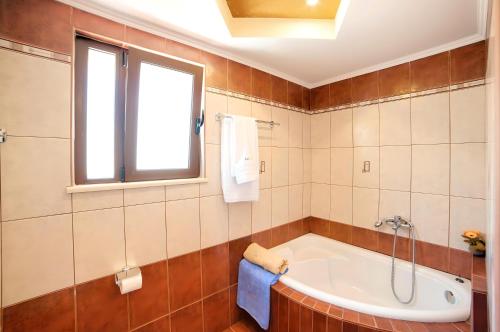 a bathroom with a tub and a window at Sunlight Villa Beheizter Pool in Georgioupolis