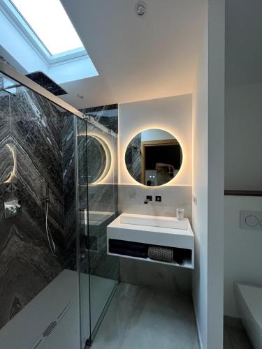 une salle de bain avec un lavabo et un miroir dans l'établissement EHDΞN Biarritz Arbonne, à Arbonne