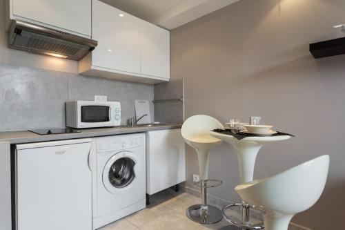 une cuisine avec un lave-linge et un micro-ondes dans l'établissement Nice flat near sea and center, à Nice