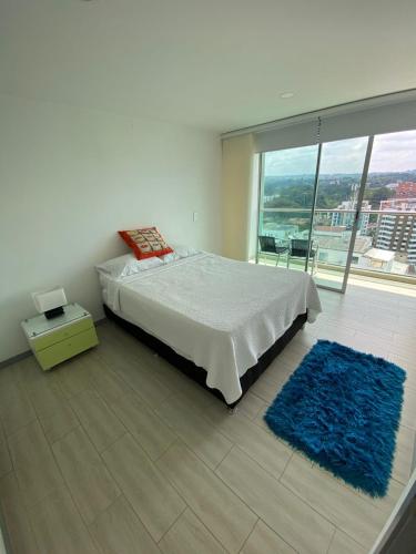 a bedroom with a bed and a large window at Apartamento in Pereira