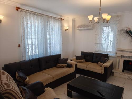 a living room with two couches and a fireplace at Villa Yelken Oludeniz in Ovacik