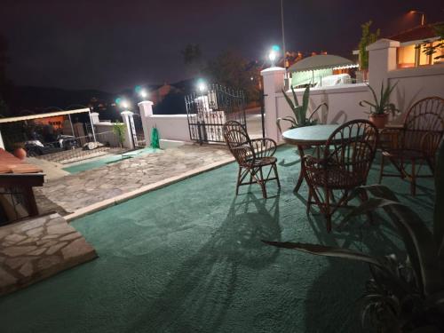 a patio with a table and chairs at night at Villa Yelken Oludeniz in Ovacik