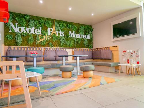 a restaurant with a waiting room with a couch and tables at Novotel Suites Paris Montreuil Vincennes in Paris