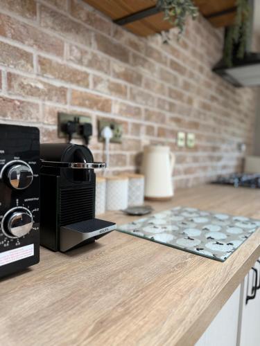 a kitchen counter with a coffee maker on a counter top at Wells Street Cottages No 26 By The River Ness in Inverness