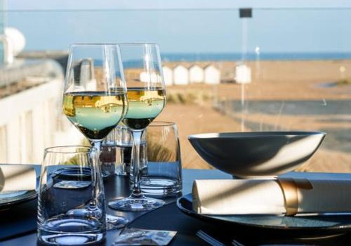 - une table avec deux verres de vin et un bol dans l'établissement Rue des hautes lumières ouistreham Mer et campagne 3 chambres, à Saint-Aubin-dʼArquenay