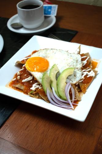 a plate of food with an egg on top of toast at Hotel Boutique AB in Momoxpan