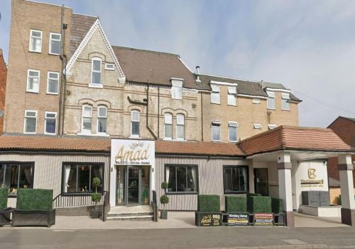 a large brick building with a store in front of it at The Continental Hotel, Derby in Derby