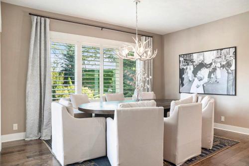 a dining room with a table and white chairs at Luxury Stay with Golf Simulator and 3 King Bedrooms in Elkhorn