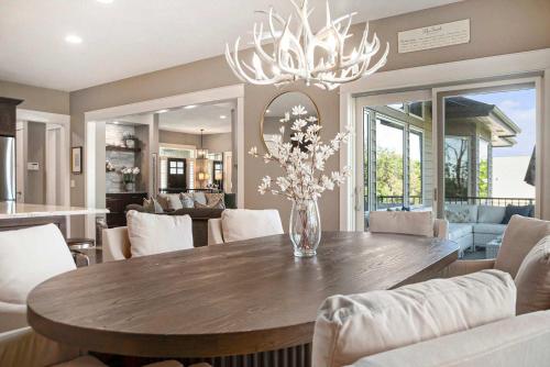a dining room with a table with a vase of flowers at Luxury Stay with Golf Simulator and 3 King Bedrooms in Elkhorn
