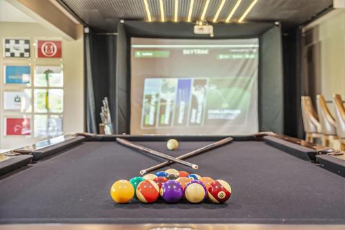 a pool table with cue sticks and balls on it at Luxury Stay with Golf Simulator and 3 King Bedrooms in Elkhorn