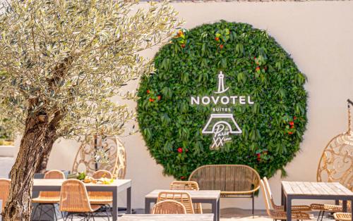 a large green wreath on a wall with tables and chairs at Novotel Suites Paris Montreuil Vincennes in Paris